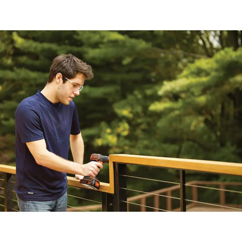 Person using 20V Max PowerConnect Cordless Drill Driver with Autosense Technology and built-in LED light on a wooden railing.
