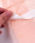 Applying adhesive strip to Prime Knockout Protection Disposable Underpads 30 By 36 Inches Super Absorbent Bed Pads.