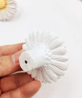 Hand holding Daisy Design Vintage Resin Drawer Pull, showcasing hand-painted white resin, for country kitchen cabinets.