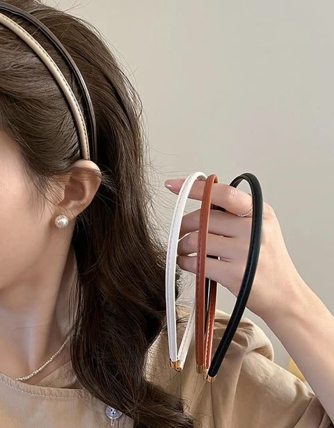 Premium Skinny Leather Headbands For Women Five Piece Set held in hand, featuring soft top grain leather in neutral colors.