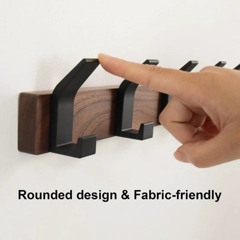 Hand pointing at Wall Mount Coat Rack With Five Hooks 16.9 Inch Walnut Wood And Aluminum Built To Last Rustproof Coat Hanger.