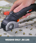 Close-up of Zip Snip Cordless Electric Scissors cutting bee-patterned fabric, highlighting its lightweight design and clean cuts.