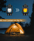Battery Operated LED Vintage Lanterns With Remote shown in front of a lit camping tent, showcasing flickering flame effect.