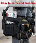 Person holding a Toughbuilt tool tote with multiple pockets and tools, showcasing a compact and organized design.