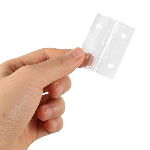 Hand holding one of Two Sets of Mini Acrylic Hinges for Wooden Boxes and Crafts, showcasing size and transparency.