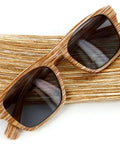 Top Tier Faux Wood Bifocal Reading Sunglasses With Plus 1.50 Power and Full Sun Blocking Spring Hinge Frames on a textured surface.
