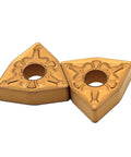 Two gold carbide turning inserts, WNMG080408, for steel turning on CNC lathes.