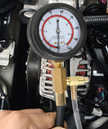 Front view of BETOOLL fuel pressure test gauge 0–100 PSI with brass T-fitting and hose attached to engine