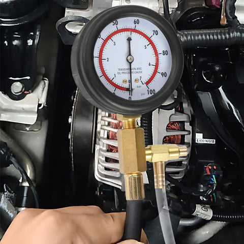 Front view of BETOOLL fuel pressure test gauge 0–100 PSI with brass T-fitting and hose attached to engine