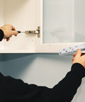 Person installing heavy duty 360-degree hidden pivot door hinges for wooden cabinets and secret bookcase, stainless steel.