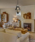 Living room with Farmhouse Pendant Light With Crackle Glass Shade In Matte Black Metal Cage Base above seating area.