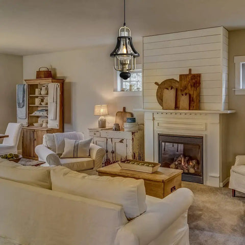 Living room with Farmhouse Pendant Light With Crackle Glass Shade In Matte Black Metal Cage Base above seating area.