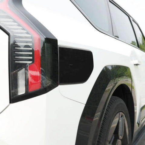 Fresh Glossy Black EV Charging Port Cover Trim Compatible With Kia EV9 2024 2025 2026 on white car side.