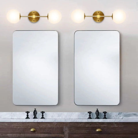 Modern Wall Sconce 2 Light Industrial Mid Century Vanity Light With White Globe Glass Shade Brushed Brass Gold Finish mounted above mirrors