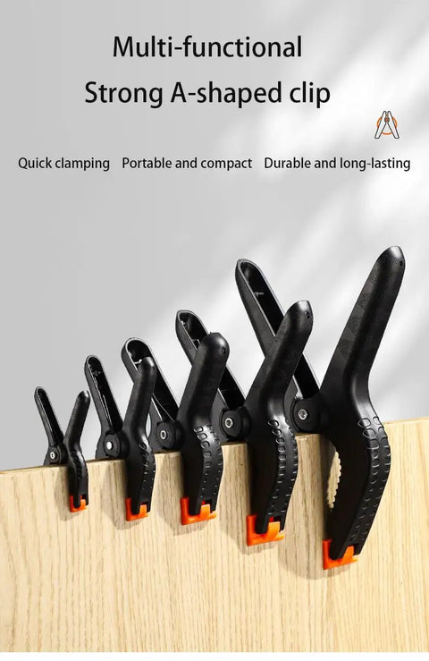 Grab This Heavy Duty Plastic Spring Clamps 20 Pack For Woodworking, Balloon Arch Backdrop And Tarps With Multi Size Durability Hand Tools That Are Totally Sick. Black A-shaped plastic spring clamps in multiple sizes on wood