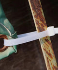 Close-up of 15 Inch Zip Ties White securing rusted metal and fabric, UV resistant, for outdoor and indoor use.