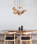 Handmade Solid Wood 19 Light Pendant Chandelier With Drop Dead Gorgeous Art Flower Petals And Smart Led Tech Generating Heavy Ambient Vibes For Your Interior Setup hanging above a wooden dining table
