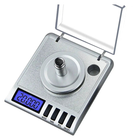 Close-up of a Straight Up Dead Accuracy 0.001g Digital Pocket Scale with a blue backlit LCD display, measuring tools for jewelry and herbs.