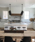 Modern kitchen featuring a white interior, wooden dining table, grey bar stools, and Pro Level Reactive Water Based Interior Wood Stain.