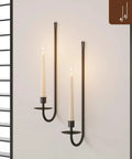 Rock Solid Black Iron Wall Candle Sconces Set Of Two mounted on wall with lit candles creating ambient lighting.