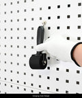 Gloved hand holding All In One Vinyl Wrap Roller Kit Pro Grade 2 In 1 Rivet Brush Applicator With Weeding Pin on pegboard