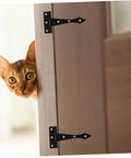 Installed: two black iron cabinet hinges on a wooden door; cat peeking from the edge