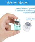 Front view of a 5ml glass injection vial with a metal sealing cap held by fingers, containing clear teal liquid.