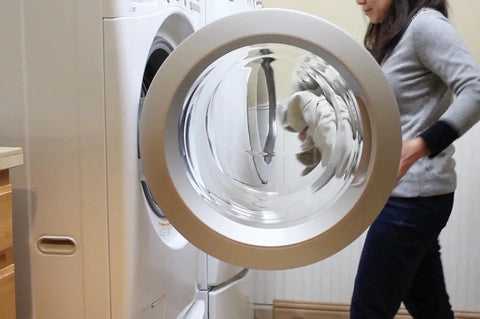 Person handling laundry in front-loading washing machine