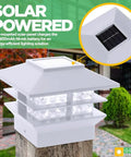 Close-up of Eight Pack Solar Powered LED Post Cap Light with two tier design, white finish, on a wooden post in an outdoor setting.