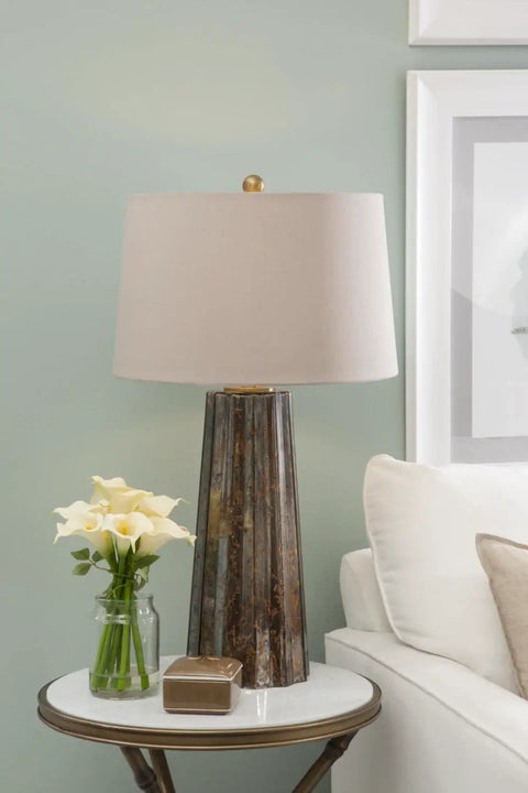 Fluted Obelisk Copper Mercury Glass Table Lamp With Weathered Industrial Finish as a centerpiece on a white side table.