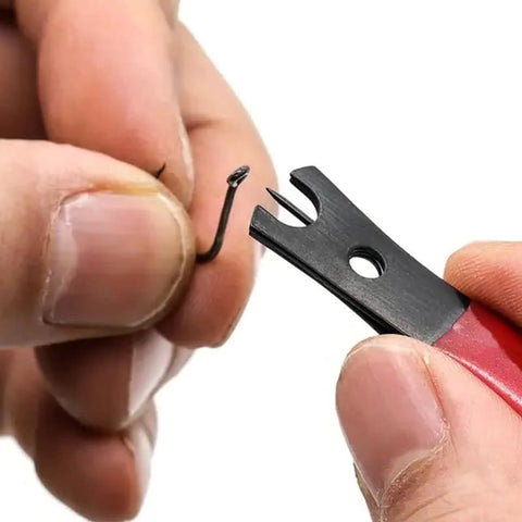Close-up of Premium Stainless Steel Line Cutter with Ergonomic Handle cutting a fishing hook, ideal for saltwater use.