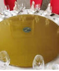 63" Gold Tempered Glass Heavy Duty Lazy Susan - Turntable Bearing Base on a dining table with elegant glassware.