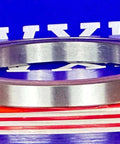 6711-2RS Thin Section Bearing 55x68x7mm side view on a colored background, showcasing its slim chrome steel design.