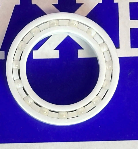 6803 Full Ceramic Bearing 17x26x5mm close-up view on a blue background, showcasing its ceramic design and bearings.