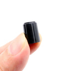 Close-up of Ten Pack Of 6mm D Type Potentiometer Knobs for Volume Control, black plastic, held between fingers, 11x15mm, for guitars and mixers.