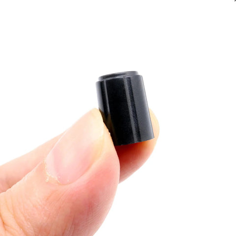 Close-up of Ten Pack Of 6mm D Type Potentiometer Knobs for Volume Control, black plastic, held between fingers, 11x15mm, for guitars and mixers.