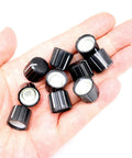Hand holding 10 Pcs 6mm D Type Potentiometer Knobs For 6 Mm Shaft Dope Volume Tone Rotary Knobs For Encoder Electric Guitar Speaker DJ