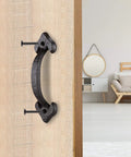 Front view of 7 Inch Heavy Duty Cast Iron Barn Door Handle Medieval Rustic Gate Pull in vintage black on wooden door