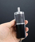 Hand holding Beefy Heavy Duty Planetary Gear Motor With Brushless DC 12V 24V Dual Voltage For Automation And Robotics FG Reverse PWM Speed Control 98 RPM 150 Kg Cm Torque Compact High Torque BLDC Gearmotor For Smart Machines