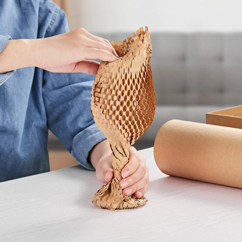 Person stretching 15 Inch By 213 Foot Honeycomb Packing Paper Bubble Wrap For Packing Shipping And Moving on table
