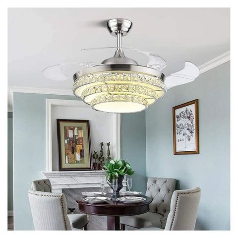 42 Inch Retractable Blade Ceiling Fan Featuring Glowing Crystal Chandelier And Smart Remote Controls For Tunable LED Lights in stylish dining room.