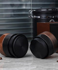 Top Shelf Wood Tamper For Espresso Makers Featuring Spring Loaded Calibration For 51mm 54mm And 58mm Portafilters, showing two tampers with walnut and black finishes.