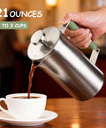 Pouring coffee from stainless steel French press into cup, showing 21 oz capacity green handle portable camping travel coffee press