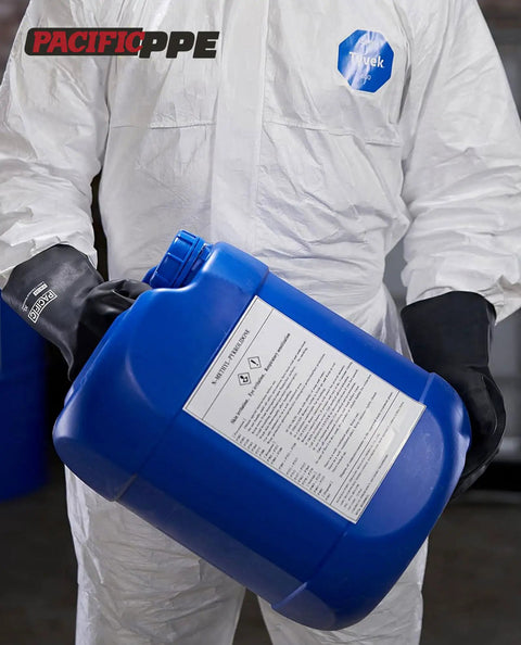 Person wearing chemical resistant work gloves built to take a beating heavy duty industrial latex rubber gloves holding blue container
