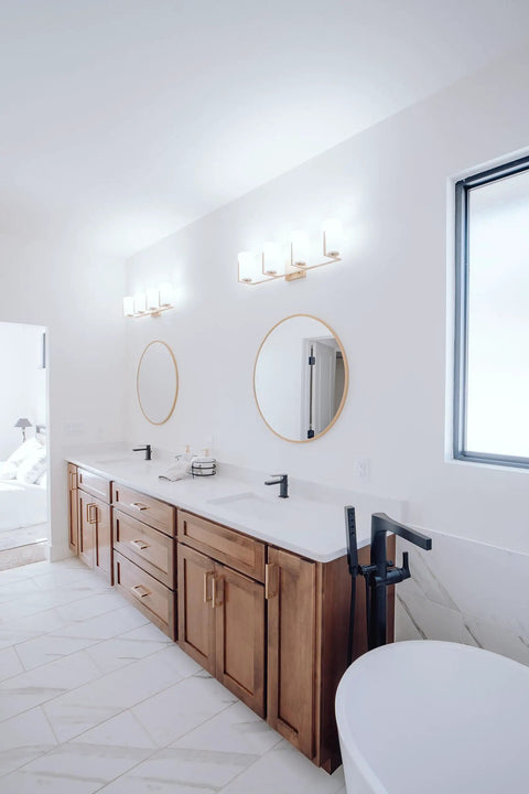 Bathroom with double vanity, mirrors, and brushed golden brass solid core kitchen cabinet pulls seen in brushed gold finish.