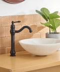 Matte Black Vessel Sink Faucet With 360 Degree Swivel on wooden countertop next to white sink bowl