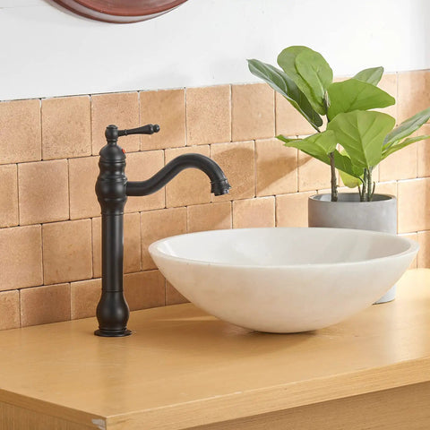 Matte Black Vessel Sink Faucet With 360 Degree Swivel on wooden countertop next to white sink bowl