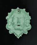 Heavy Duty Cast Iron Celtic Green Man Wall Plaque Sporting A Dead Cool Antiqued Verdigris Finish Standing Ten Inches Tall hanging on a wall.