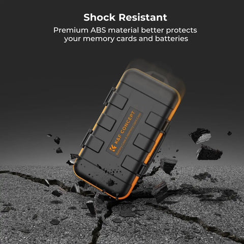 Rugged Water Resistant Camera Battery And Card Case shockproof in black and orange, demonstrating durability on cracked pavement.