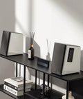 R1700BT Bluetooth Bookshelf Speakers With 66W RMS Power on display in a sleek white wood enclosure on a black shelf